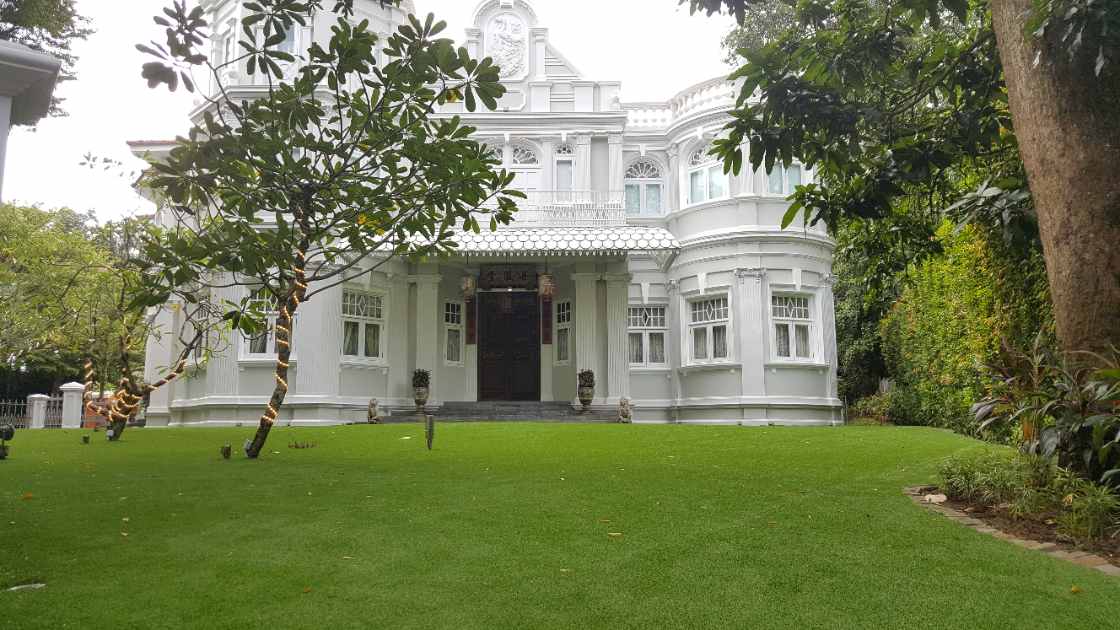 Finished lush green Namgrass artificial grass lawn framing a grand white heritage bungalow in Singapore